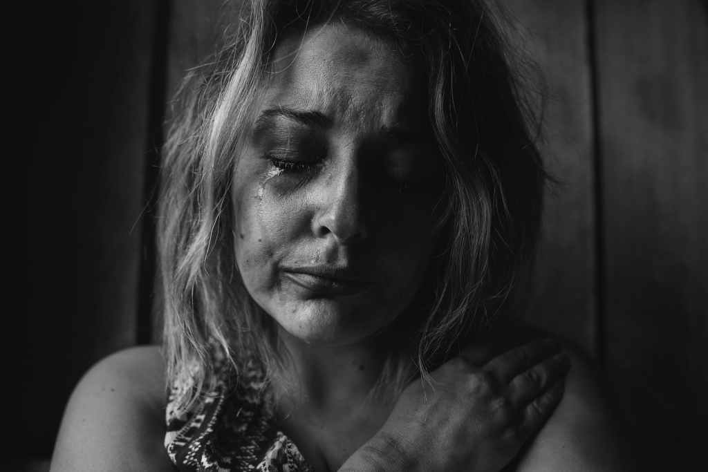 A woman crying with a very sad expression on her face.
